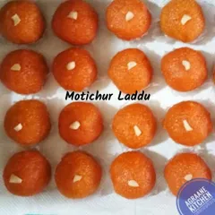 These are our Motichur Laddus, made from tiny droplets of gram flour batter fried in ghee and then soaked in sugar syrup. Each laddu is soft, juicy, and garnished with a piece of nut.