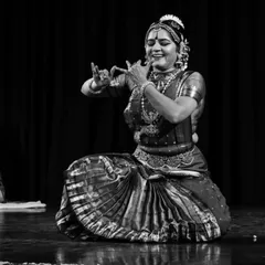 A black and white photograph capturing the pure joy of dance. Even without color, the emotion of the performance shines through in this moment of expressive abhinaya.