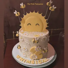 A cheerful "Whimsical" sunshine and bees cake. This design is perfect for a second birthday, with a happy sun and cute fondant bees buzzing around daisies.
