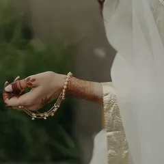 A detail shot of the bride's delicate hathphool, a piece of bio-jewellery that adds a conscious and modern touch to her traditional look.