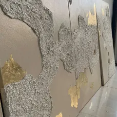 The texture on these panels is designed to look like weathered, ancient surfaces, with the gold leaf appearing like a precious discovery.