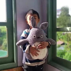 My son holding the handmade Totoro plush. It’s a joy to see my creations loved by family.