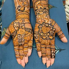 A gorgeous pair of hands adorned with floral and peacock mehendi. The design is asymmetrical, with each hand having a unique composition, yet they complement each other perfectly.