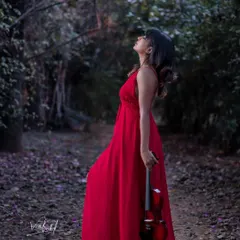 A 'woman in red' concept, set in a quiet, magical forest. This shot is all about creating a dreamy, painterly mood, where the vibrant dress stands out against the serene nature, telling a story without a single word.