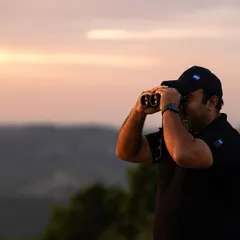 Scanning the horizon at sunset. A huge part of my job is not just photography, but patiently watching and waiting, understanding the environment to predict where the animals will be.