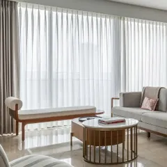 A glimpse into our 'House Nandini' project as featured in Elle Decor. The living room is bathed in natural light, where we used sheer curtains to create a soft, ethereal glow, highlighting the clean lines of the contemporary furniture.
