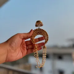 A traditional 'Khopa' hair accessory, designed to be worn on a hair bun. This piece, with its pearl chains and jhumka, adds a final touch of grace to a Maharashtrian look.