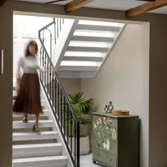 A hand-painted chest of drawers adds a unique, artistic touch to this staircase landing. We believe in incorporating pieces that tell a story and add personality to a home.