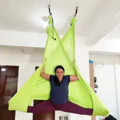 A student in our TTC program explores aerial yoga, one of the many styles we cover in our multi-style training.