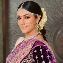 For this traditional ceremony, I designed a look that was both regal and ethereal. The makeup features softly sculpted features and luminous skin, harmonizing perfectly with the rich purple silk saree and classic diamond matha patti, creating a timeless bridal portrait.
