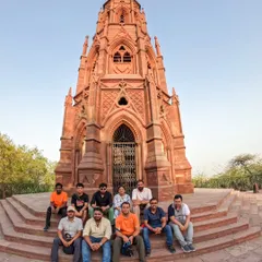 Our group poses for a photo at the Mutiny Memorial on our Northern Ridge Walk. This tour is a deep dive into the history of the 1857 uprising, set against a backdrop of lush forest.