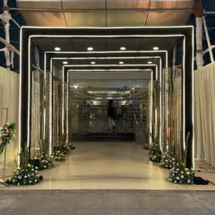 This modern and chic entrance uses clean lines and LED-lit arches to create a futuristic tunnel effect, perfect for a contemporary wedding reception or sangeet night.
