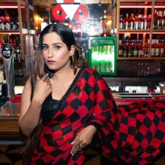 A direct and confident portrait of the influencer at the bar. This kind of shot is great for connecting with an audience and showcasing both the outfit and the individual's personality.