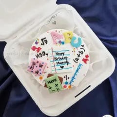 A bento cake I designed for a teacher. It's decorated with fondant books, mathematical formulas, and a little note saying "Happy Birthday Mummy," as it was a gift from her child.