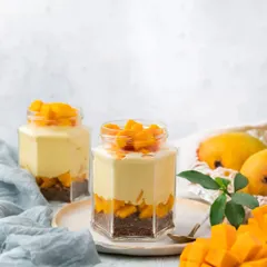 Our Mango Mousse Jar is a light and airy dessert. We layer velvety smooth mango mousse over a cocoa biscuit crumble and top it with fresh diced mangoes.