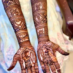 This design captures the beautiful varmala ceremony. The palms feature the bride and groom exchanging garlands, while the arms are decorated with traditional symbols like a doli and shehnai.