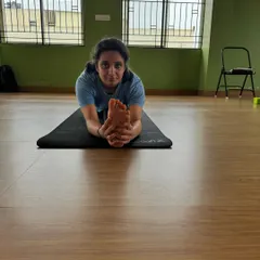 Holding the foot in a full front split forward bend. This level of flexibility is achieved through disciplined and intelligent sequencing, which we teach in our course.