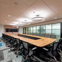 We designed this corporate boardroom with a focus on texture and pattern. The angled wood paneling on the wall is complemented by the geometric design of the carpet, making the room interesting without being distracting.