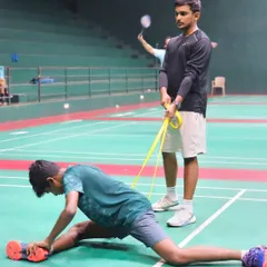 Flexibility is just as important as strength. I am assisting a player with a resistance band stretch to improve their range of motion and prevent injuries.