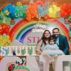 A lovely family photo in front of the vibrant Cocomelon themed backdrop for Stuti's first birthday. I ensure the colorful party decor is highlighted in your family portraits.