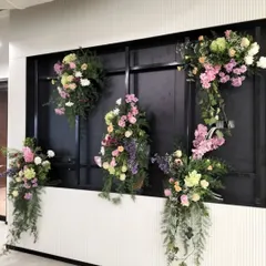 We use floral installations to transform standard office features into points of interest. This floral decor on a modern black-paneled wall added a touch of nature and sophistication to an inaugural office event, enhancing the existing architecture.