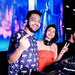 Posing with a fellow DJ behind the decks. Collaboration and sharing the stage with other talented artists is a big part of the nightlife scene.