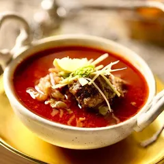A close-up of my Mutton Nalli Nihari, a rich and aromatic slow-cooked stew. The meat is so tender it falls off the bone, served in a spicy, flavorful broth and garnished with ginger and lime.