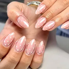 When life gives you dots, wear them on your nails. A classic and cute set of sheer pink nails with tiny white polka dots, perfect for a simple yet playful look.