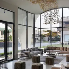 In this modern outhouse, we used seamless glass walls to dissolve the boundary between the living area and the garden. The double-height windows offer boundless views, making nature an integral part of the interior design and filling the space with light.