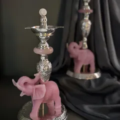This piece is a 'jyot' or traditional oil lamp, supported by a rose quartz elephant. It combines the sacred flame with the gentle strength of the elephant.