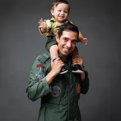 A classic father-son moment of pure fun. Having his son on his shoulders brings a huge smile to this proud dad's face.