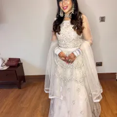 A full-length view of this angelic white lehenga look. The glittery silver eye makeup and statement jewelry make it perfect for a sangeet or reception.