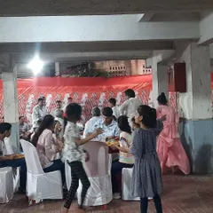 Guests enjoying our food at a family function in Vashi. We provided tables and chairs with clean white covers, creating a comfortable dining experience for adults and children alike.