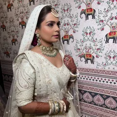 A side profile of this minimalist bride. The focus is on flawless skin and a soft, neutral makeup palette that enhances her natural beauty against the stunning wallpaper.