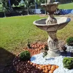This classic style bird bath fountain becomes the centerpiece of the garden. We surrounded it with a mix of brown and white pebbles to create a clean and decorative base.