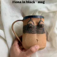 Here is the 'Fiona' mug in black, offering a bolder take on the design. The contrast between the dark carving and the natural clay body highlights the intricate linework.