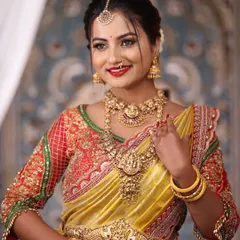 This bride is glowing in a classic temple jewellery set. The combination of a choker and a longer Lakshmi haram, paired with a matching waist belt, creates a complete and regal bridal look.