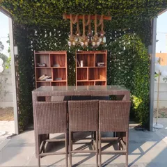 We created this cozy outdoor bar and seating area using a trellis structure covered in artificial leaves. The setup includes a high table and shelving, perfect for entertaining.