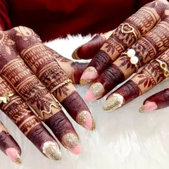 The perfect pairing of blush pink and gold glitter for a festive bridal look. This set, shown against beautiful mehndi, combines soft color with high-impact sparkle, ideal for any wedding celebration.