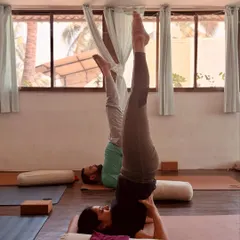 Students practice a supported shoulder stand variation during our workshop. Using props like bolsters makes inversions accessible and allows for a deeper restorative experience.