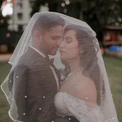 A classic Christian wedding portrait, using the bride's veil to create a soft, romantic frame around the couple. This shot highlights our ability to blend traditional poses with a touch of modern artistry.