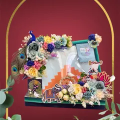 Festivals are all about vibrant joy, and I love creating hampers that reflect that. This Teej hamper is a burst of colour, featuring a peacock motif, rich peacock feathers, and a multi-hued floral design to pack sarees and gifts with a festive spirit.