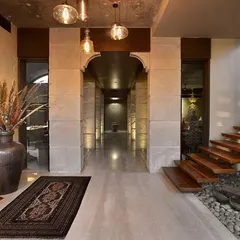 This floating wooden staircase is set against a bed of river pebbles, bringing a natural, Zen-like quality indoors. The design is clean and minimal, allowing the texture of the stone pillars and the warmth of the wood to stand out.