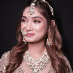 A portrait showing a heavy kundan and mint green stone jewellery set. This is a popular rental for pairing with pastel lehengas.