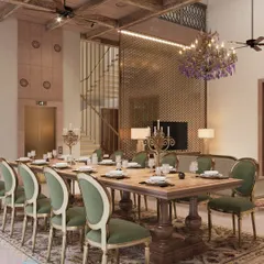 This grand dining space is designed for large family gatherings, featuring a long wooden table and classic upholstered chairs. A modern brass jali screen and a statement chandelier add layers of texture and light, blending contemporary luxury with heritage design.