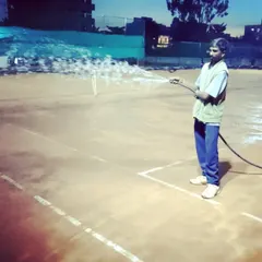 A close-up of the court watering process, a crucial step in maintaining high-quality clay surfaces.