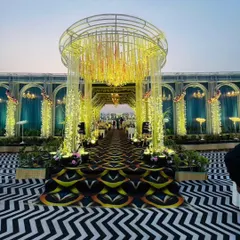 This grand entrance arch, adorned with hanging floral tassels and intricate lighting, was designed to be the perfect gateway to the main event. It sets a tone of opulence and celebration from the moment guests arrive.