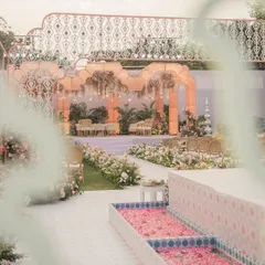 A view of the 'Gulab Bagh' wedding aisle, flanked by a water channel filled with rose petals, leading towards the ethereal organza mandap.