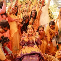 The pure, unfiltered joy of a Haldi ceremony. We love capturing these high-energy moments, with friends and family showering the bride in flower petals. It’s all about real smiles and vibrant colours.