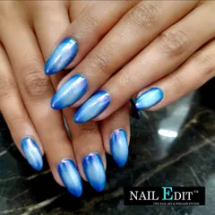 This vibrant blue cat-eye manicure shows the incredible depth and movement created by magnetic polish. The almond-shaped nails have a brilliant, metallic sheen that shifts with the light.